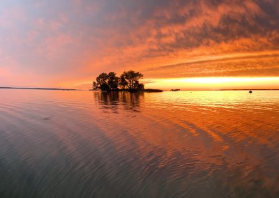 Panorama shot of Lake Ontario just after sunset with the sky and water full of golden hues; 2024 Photo Contest winner in the Panorama category, by Bridget Hughes