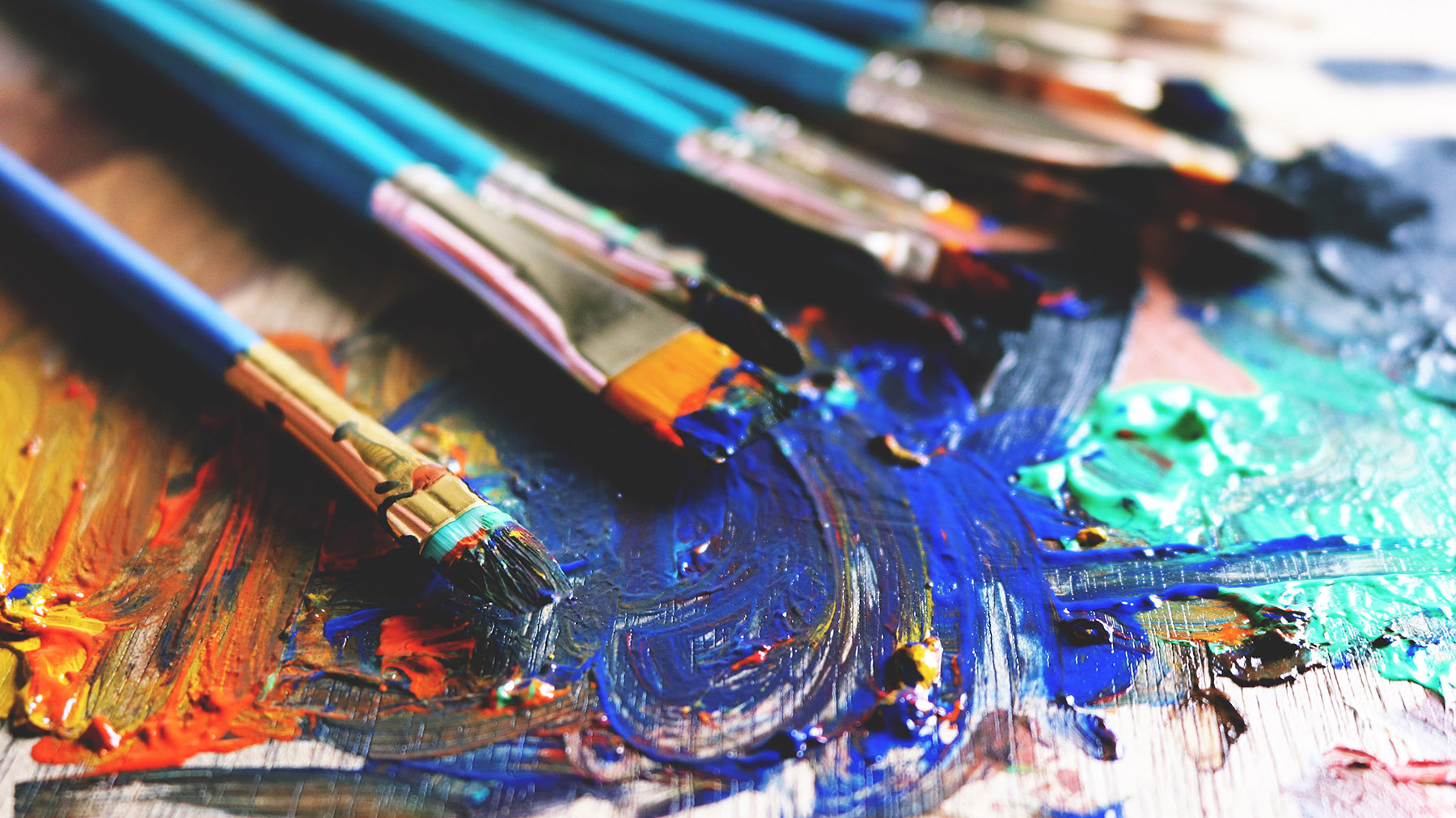 Color photo of an artist's set of paint brushes with paint on them (Public domain image, courtesy of RawPixel.com)