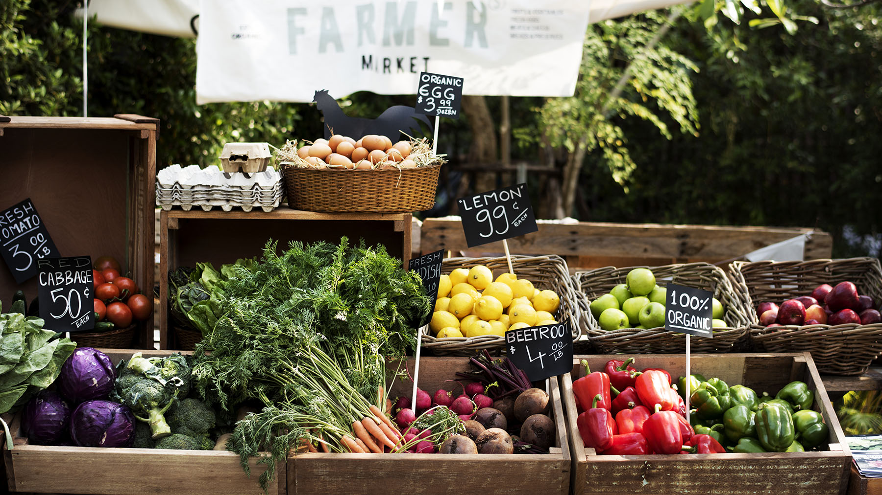 Color photo of a fruit and vegetable stand at a farmers market (Image by RawPixel.com; copyright 2017)