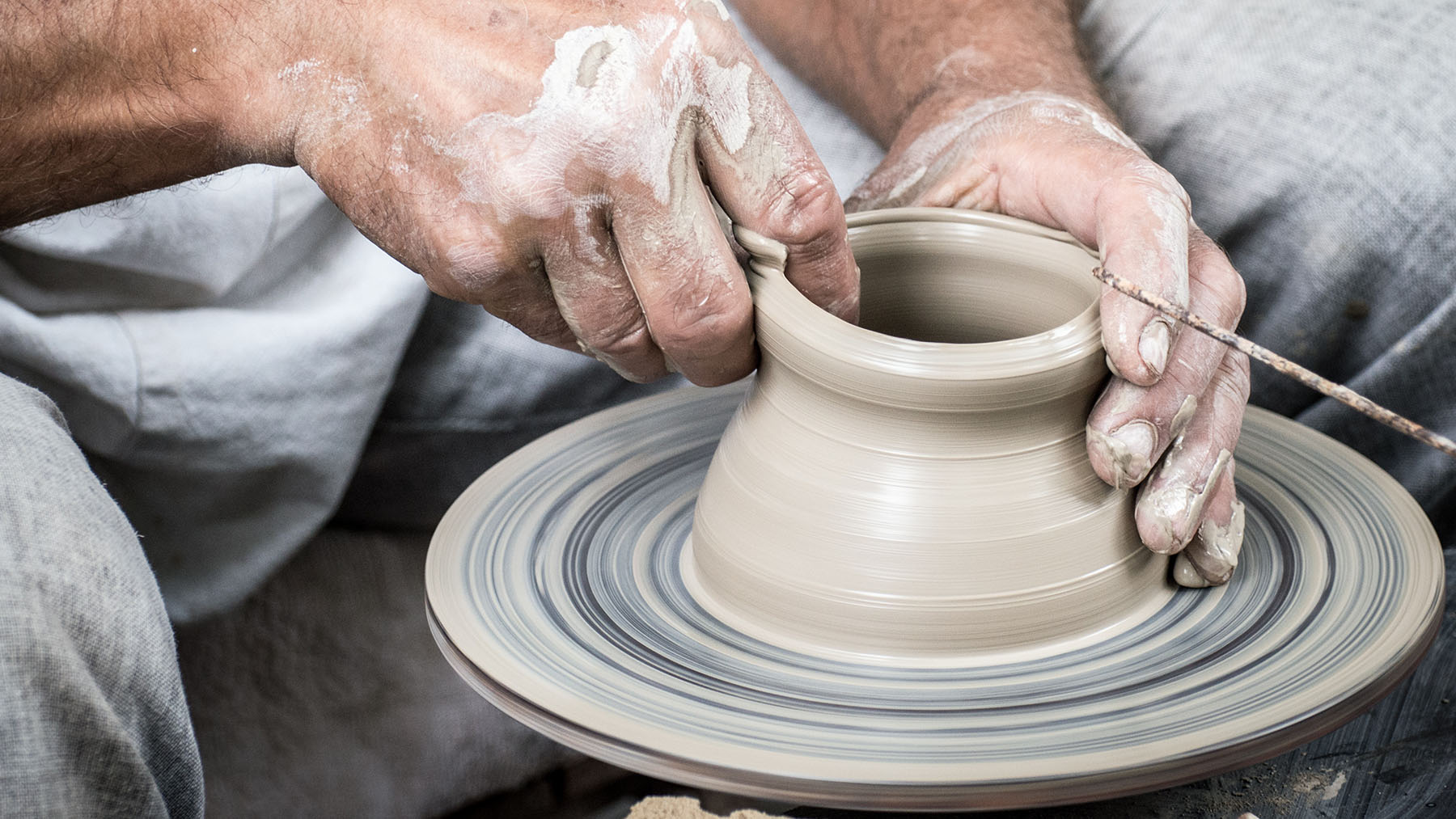Photo of a man's hands making a ceramic pot (Public domain image from Creative Commons and RawPixel.com)