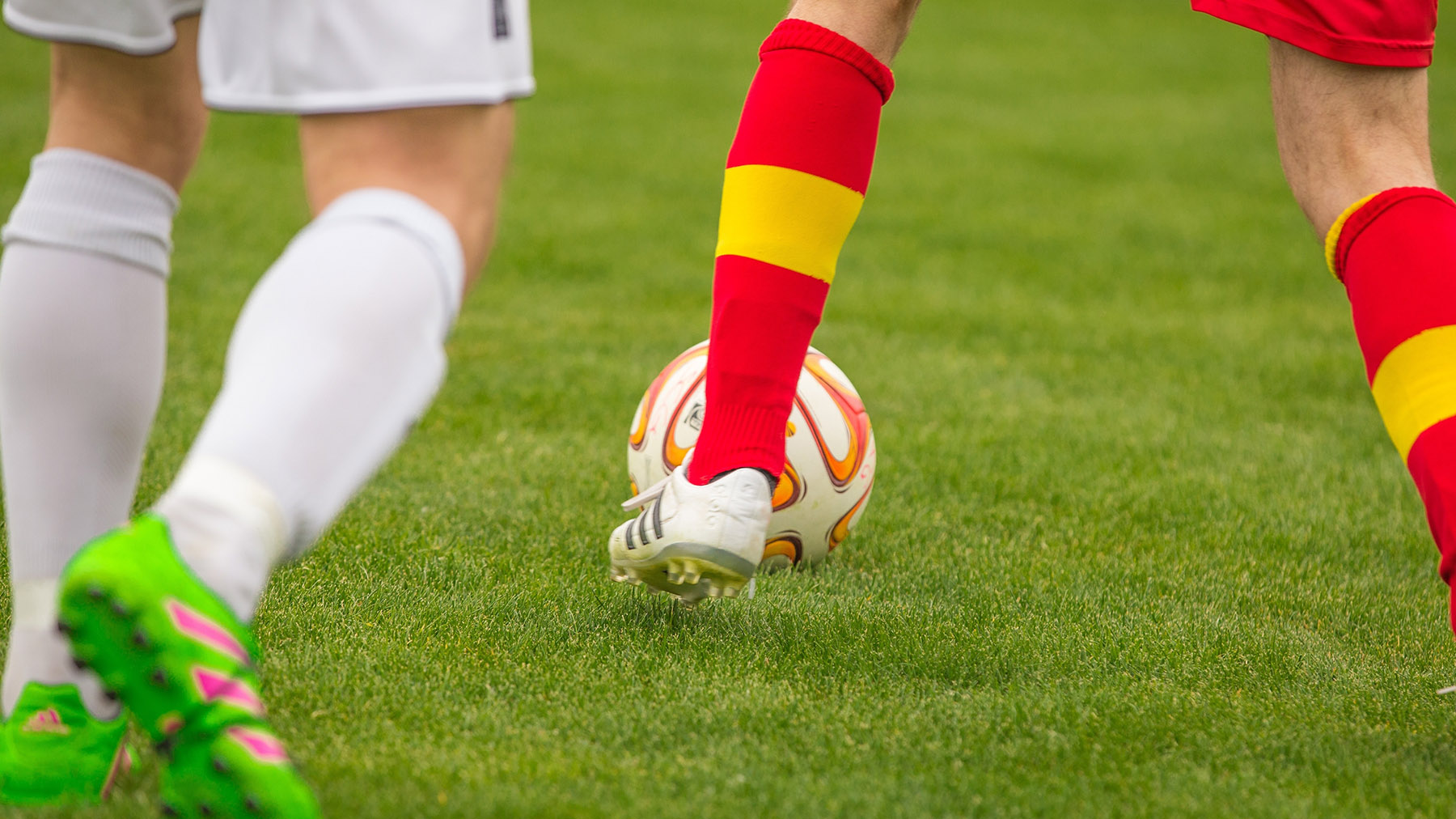 Stock photo of men playing soccer on a grass field (Public domain photo courtesy of RawPixel.com)